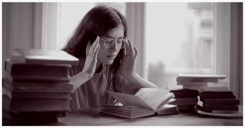 Woman having difficulty focusing while reading a book